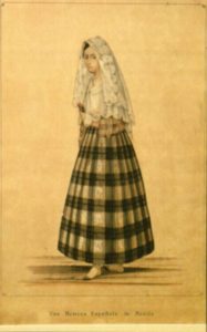 Drawing of a woman with a white embroidered scarf over her head, and a long, full black and white plaid skirt.