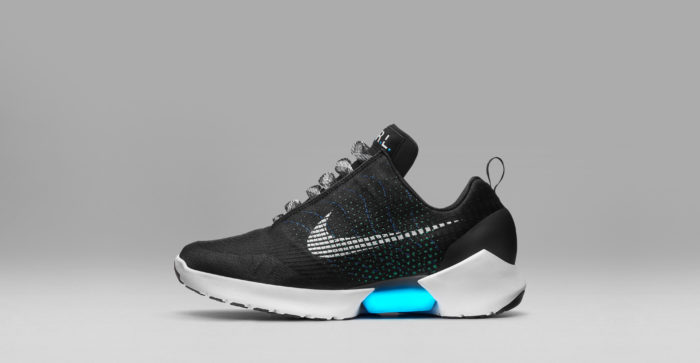 Futuristic cool black sneaker with a white sole. There is a light-up blue insert in the sole. The shoe features a gray Nike 