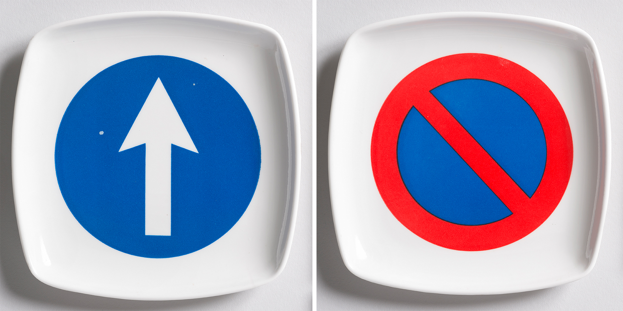 Side-by-side images of two rounded-square with ashtrays. One features a blue circle with an upward-pointing white arrow in it; the other features the 