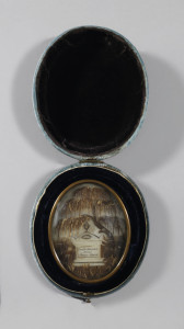 Oval brass form surrounding scene made of hair