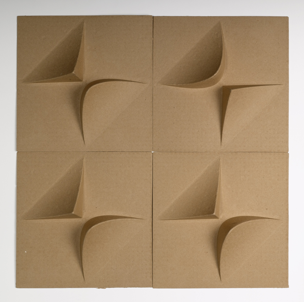 Square tiles embossed to a depth of 2.5 inches. The embossing includes 2 protrusions in alternate corners, one triangular and one rounded. The tiles are a natural brown in color and can be installed in many different patterns on the wall or ceiling. Produced from 100% post and pre-consumer recycled paper