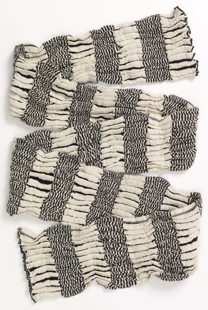 Double cloth of thick and thin stripes in black and white. Vertical bands of thick black and white stripes alternate with horizontal bands of thin black and white stripes. Overtwisted black threads create a puckered effect.