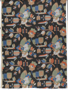 Length of printed linen with a bold, large-scale design of highly stylized flowers in blue, green, light gray, orange, and orange-tan on a printed black ground.