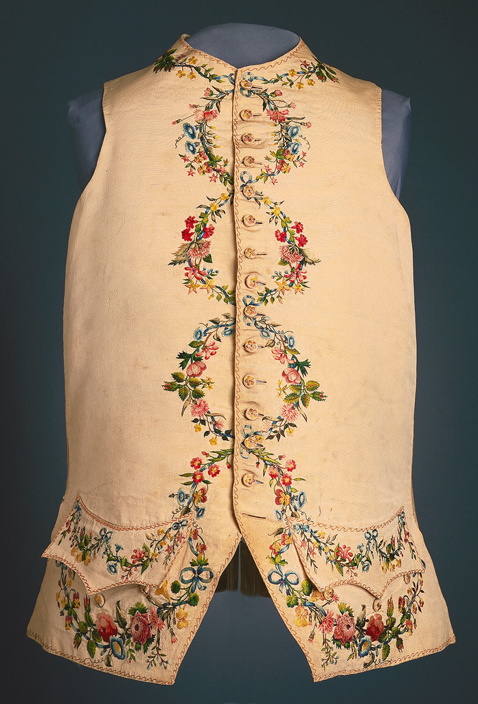 Gentleman's waistcoat in ivory silk faille with embroidery on collar, pockets, center fronts and lower edge. Embroidered in 22 shades of silk with floral garlands which form circles down the center front when the waistcoat is buttoned.