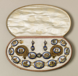 Suite of jewelry with gold filigree mounts around micromosaic oval scenes of Rome in cobalt blue borders; comprising a necklace centered by a view of St Peter's, with various ruins, and the Colisseum, and Pantheon; a pair of gold bracelets each with one arch view, a pair of earrings, and a pair of brooches.