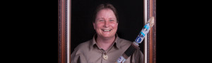 woman standing inside a picture frame holding an ornate walking stick.