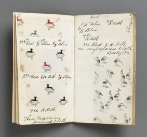 book opened with a page with inserts of textile with dogs and birds