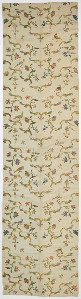 Bed hangings of heavy white silk, embroidered in gold thread, gold foil strips, and colored silks. Each panel is made up of two breadths of fabric seamed down the center and is lined in white silk plain weave. The design is arranged so that golden rococo curves meet at the center seam to form a symmetrical v-shaped pattern, with flowering branches and birds, worked in satin stitch in colored silks. While the flowers are symmetrical, the birds are vertically off-set; each panel shows eleven birds, all different, which appear to be taken from a set of ornithological prints by Xaviero Manetti. Metallic effects in several textures are created with couched crimped gold lamella and couched foil-wrapped silk-core threads.