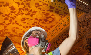 woman restoring ceiling of the teak room in the carnegie mansion