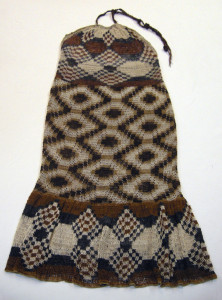 Halter-style dress with a tie at the neck in tan, dark brown and dark blue. Looping is tighter in the mid-section to form a waistband. Deep flounce at the bottom. Pattern is geometric.