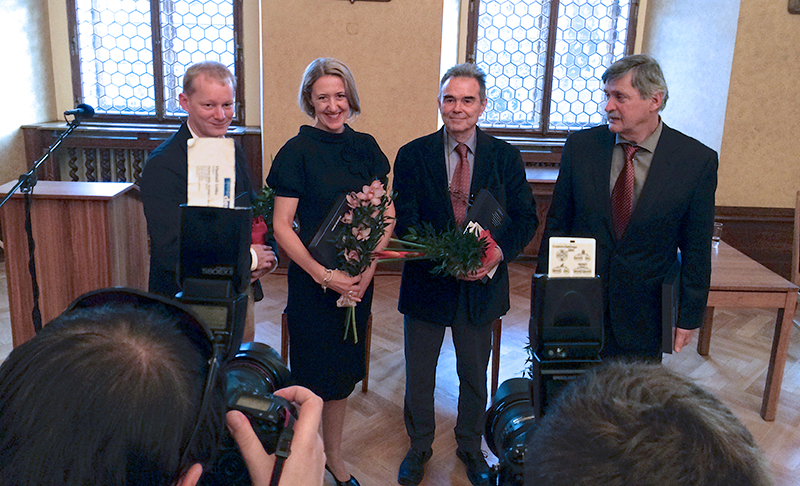 Cooper-Hewitt Museum director Caroline Baumann standing for a portrait with three others. They are in somewhat formal dress and holding flowers.