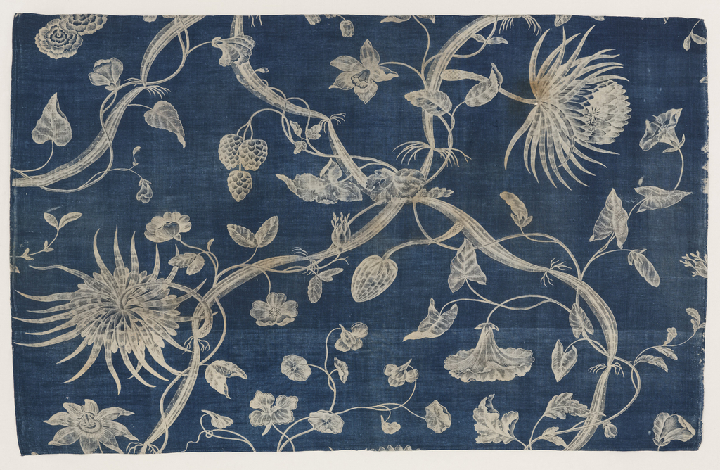 Length of printed cotton with a naturalistic design with nasturtiums, passion flower, and other flowers, foliage, and vines crossing and intertwining. The design appears in white on a rich indigo blue ground with etched details in blue.
