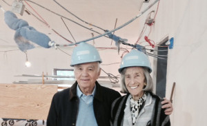Barbara and Morton Mandel pose for a picture in light blue hard hats