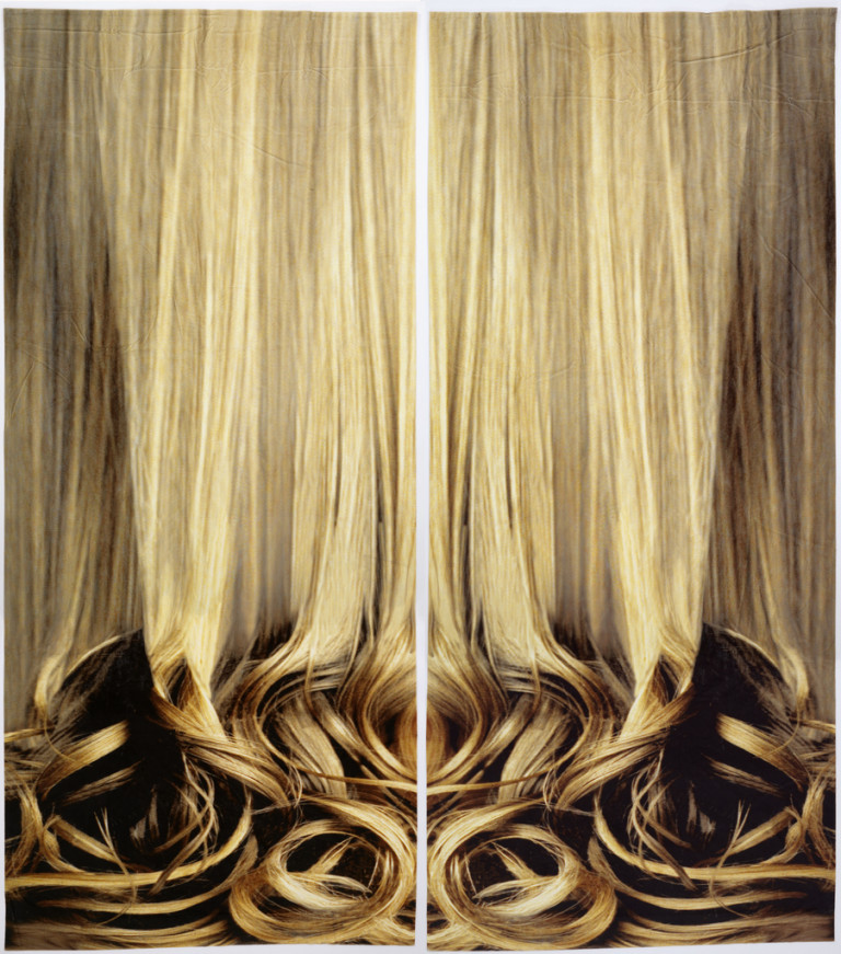 Pair of velvet curtain panels printed with a large-scale image of long blonde hair falling into curls at the bottom. Each panel printed in mirror image so that together they form a symmetrical design.