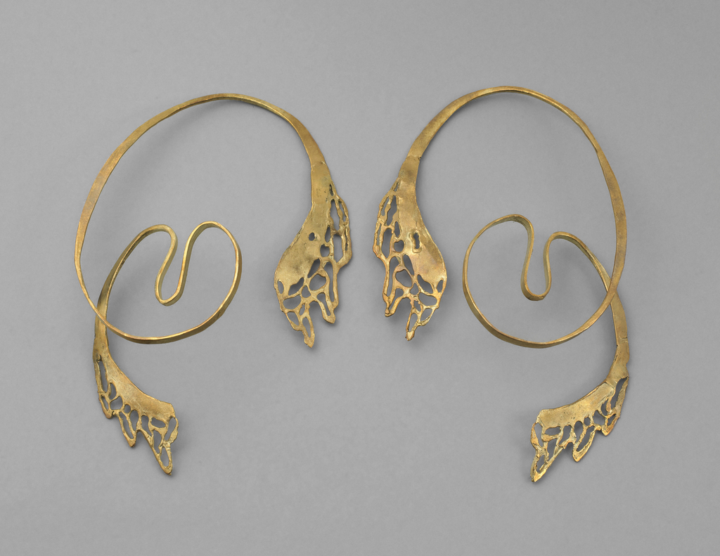Gold earrings formed into abstract curved elements. From bottom, lace-like dripping effect leading to a loop and two arches, then looping over entire earring and terminating at another lace-like dripping element.