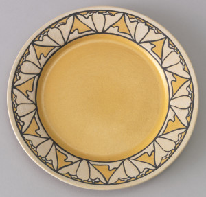 Dish with bright yellow well; border of flattened natural-colored blossoms outlined in thick black on yellow ground.