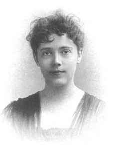 Oval vignette portrait of a calm looking woman with messy brown hair, brown eyes and simple dress.