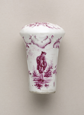 Pink and white porcelain piece, somewhat of a wine cork shape, on a beige backdrop