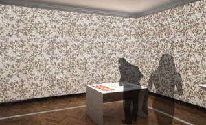 Architectural rendering of a corner of a room with sweeping wallpaper pattern on both walls and a man hunched over an interactive table beside it.