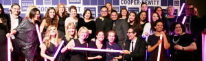 a group shot of lots of smiling people, in fancy attire in front of a step-and-repeat that says Cooper Hewitt National Design Awards all over it.