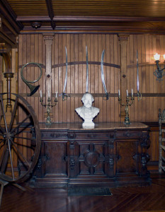 wood paneled room with furniture, marble bust and horn on wall