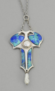 A tri-lobate cruciform pendant with blue-green enamel divided by silver supports and centered by a mother-of-pearl boss, with baroque pearl pendant from the bottom, with thin-gauge silver wire chain.