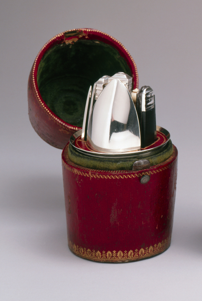 Red leather holder with stamped gold decorations for five implements, holder fits into silver cup.