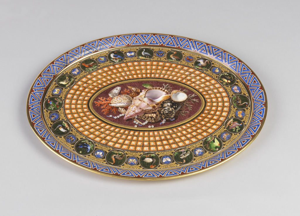 Oval tray with raised and everted rim. Decorated with outer border of interlaced triangular geometric motifs in lapis blue against brown background, surrounded by thin gold rims; then a border of tooled gilding with 16 roundels painted in polychrome of exotic birds, alternating with the smaller roundels with butterflies. Around central oval a wide band of trompe-l'oeil coffering. Center painted with arrangement of seashells, coral, and pearls against a faux marble background.