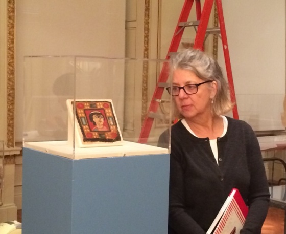 Maira Kalman gazes at the Coptic textile fragment of a face.