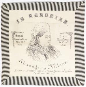 Printed handkerchief with a three-quarter portrait bust of Queen Victoria in the center. At the top, "In Memoriam." At the bottom: "Alexandrina - Victoria Queen of the United Kingdom of Great Britain and Ireland Empress of India." On the left side: "Born in Kensington Palace May 24th, 1819." On the right side "Died in Osborne House Jan'y 22nd, 1901." Printed in black on a white ground, with a black and white striped border.