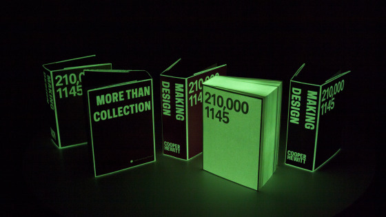five books in a dark room. the books have glowing green borders and text. one book is an inverted version of the others, with edges that don't glow and background glowing.
