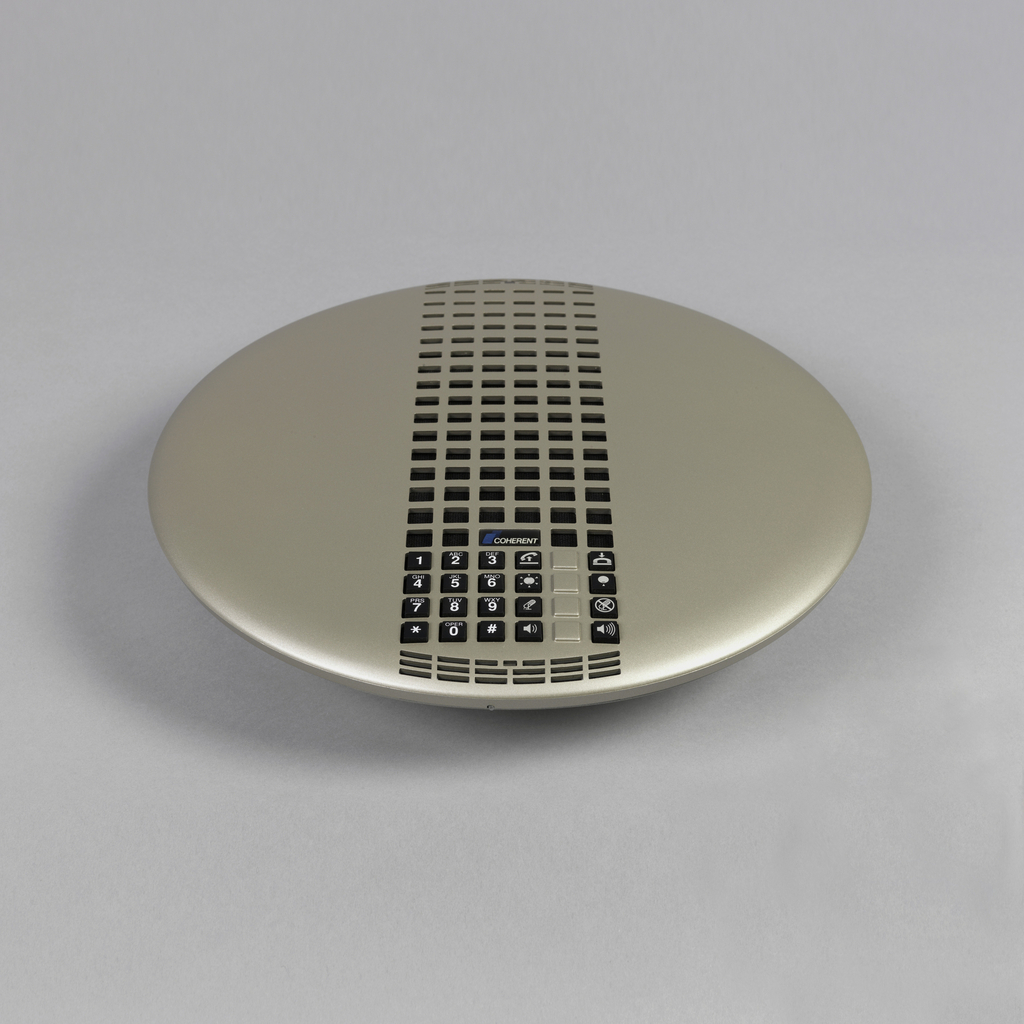 Raised disc-shaped metallic-toned plastic body, the center pierced by six columns of small squares (speaker) above square black number and function keys.