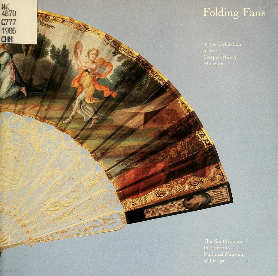 Half of a fan shown, as if peeking out from the left edge of the page. the top is a realistically painted scene on paper, the bottom is ornately carved, even lacelike white support sticks holding the paper.