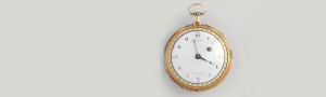 A gold pocketwatch on gray background