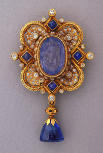 Gold brooch with oval carved sapphire cameo of Cybelle or Isis (or the Personification of Italy) seated on a throne; framed by sapphires, diamonds, and pendant with sapphire drop in gold; mounting with ruby and emerald chips.