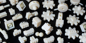 White plastic parts with various pegs and holes on a black background
