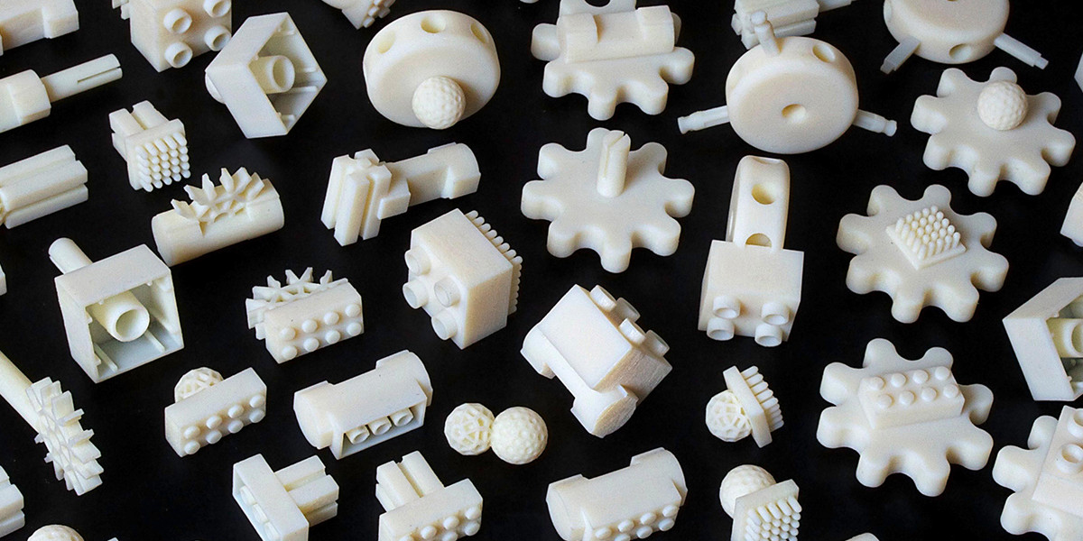 White plastic parts with various pegs and holes on a black background