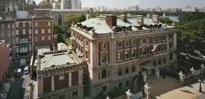 Aerial view of the Cooper Hewitt Smithsonian Design Museum with Central Park and a New York City skyline behind it.