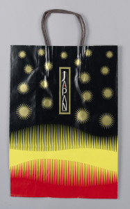Shopping back printed in black, yellow, red with gold sunbursts and one blue sunburst.
