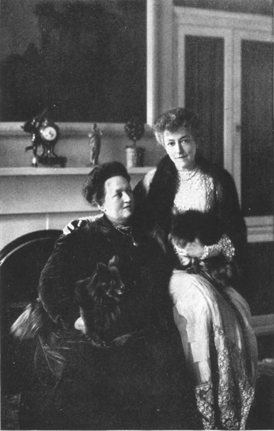 photograph of two women sitting in front of a fireplace