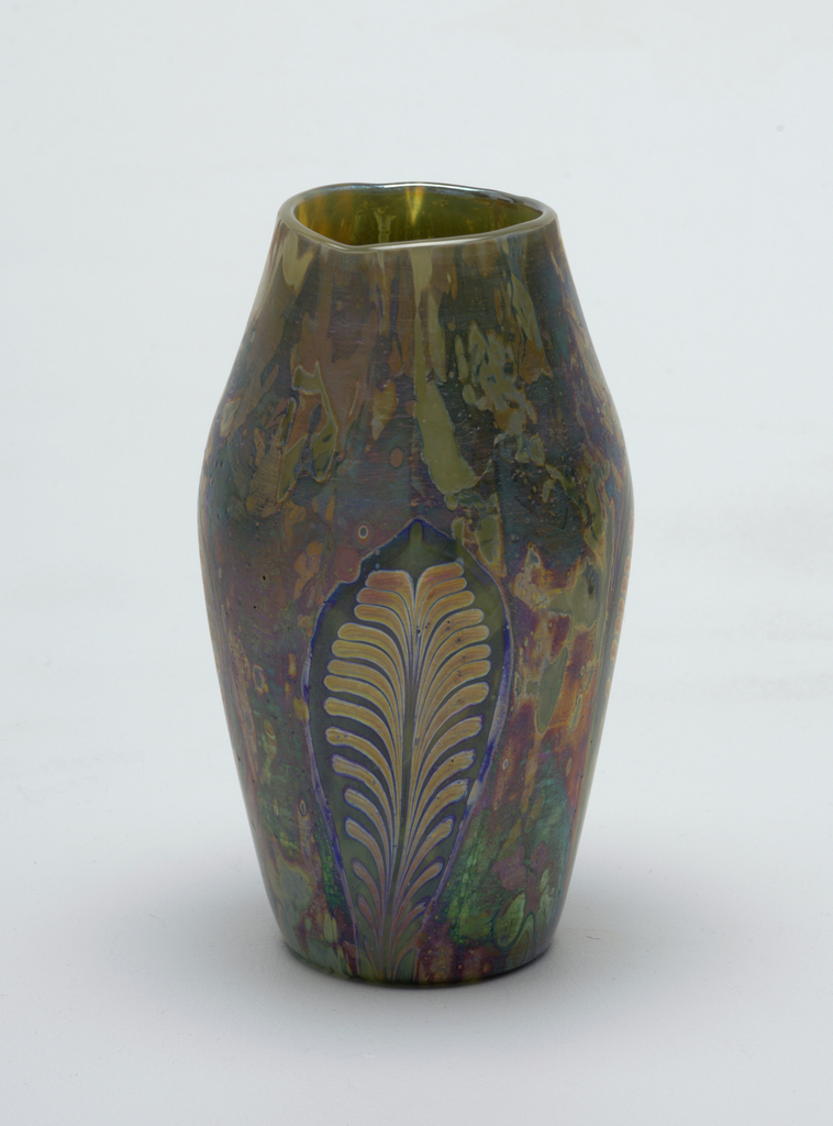 Image features glass vase of roughly ovoid from with mottled iridescent decoration in shades of gold, blues reds and greens. Please scroll down to read the blog post about this object.