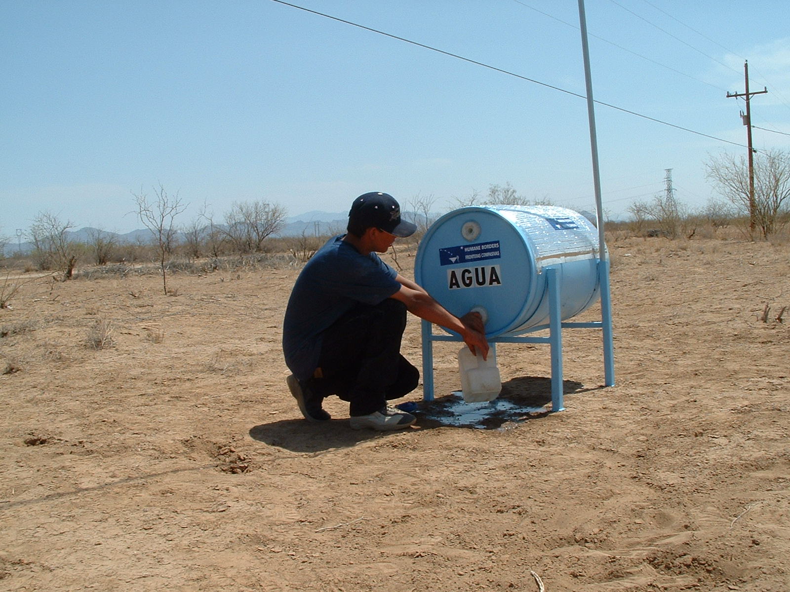 man filling jug at water station