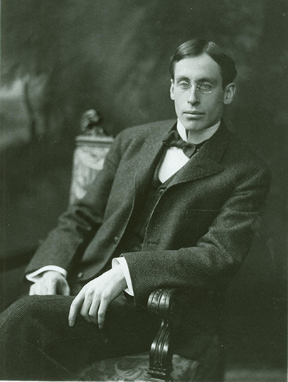 a bespectacled man sitting in a chair