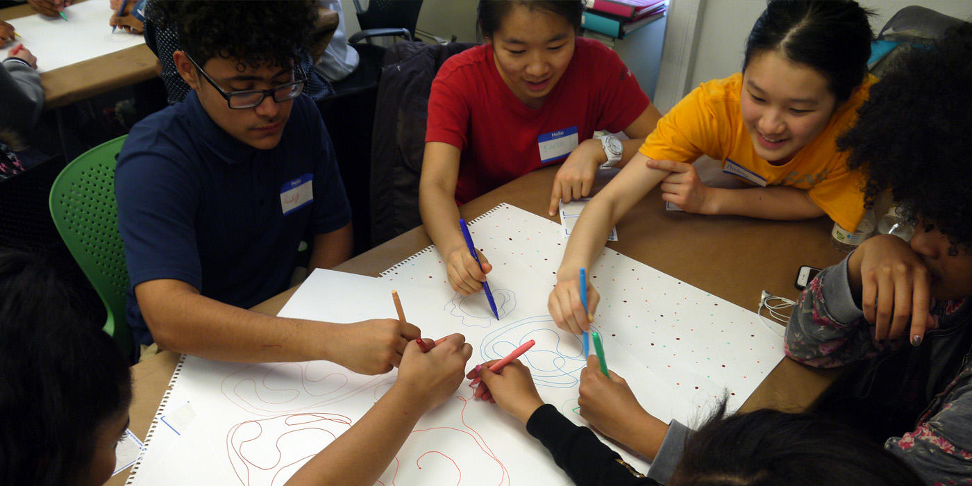 Photograph of young designers with paper and markers.