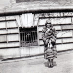 Photograph of Martha "Mattie" Clarke standing outside the mansion's service entrance