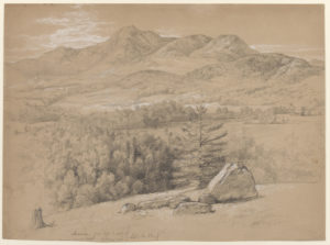 Horizontal view with trees and rocks in foreground leading to a meadow containing a lake, which spreads out before a mountain range in the middle ground, as Mount Chocorua, the highest peak, rises just left of center in the background.