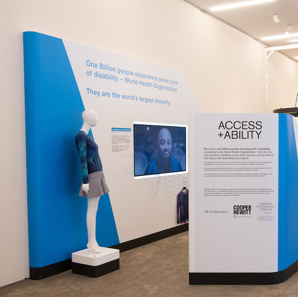A clothing manniequin wears a blue long sleeve t-shirt and grey miniskirit that are embedded with sensors to create tactile sensations in response to music shown at the entrance to the special installation of Cooper Hewitt's exhibition of inclusive design at the World Economic Forum in Davos, Switzerland. Text on the wall next to the mannequin reads "One billion people experience some form of disability—World Health Organization. They are the world's largest minority." Click here to learn more about Cooper Hewitt's participation in WEF.