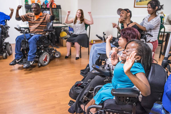 Men and women in wheelchairs take part in an exercise class at The Axis Project.