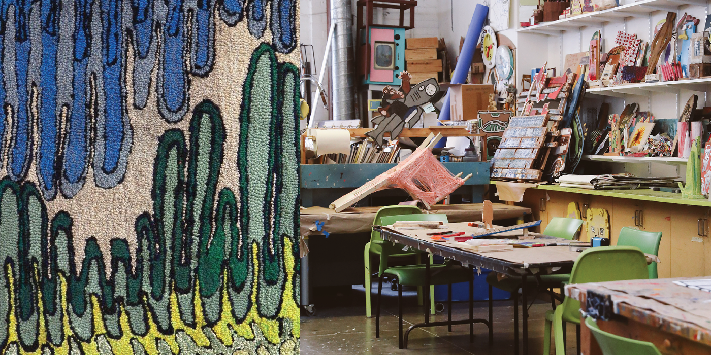 Photograph of art studio space. A rug with blue, green, yellow, and cream patterning hangs in the foreground. Artwork and supplies are in the background.
