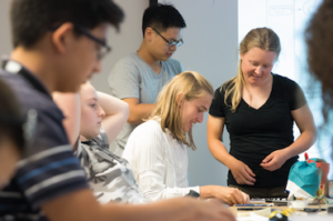 Photograph of teens participating in a design workshop. Scroll below for enrollment information.